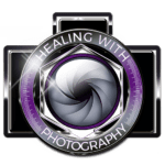company logo, black camera with purple trim around the lens. Healing with Photography.